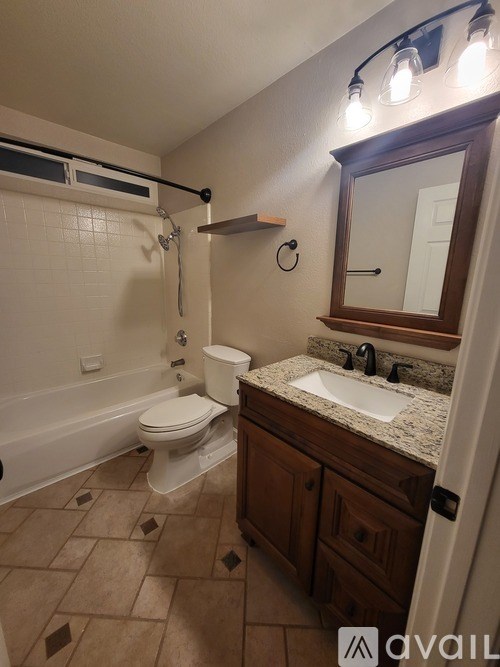 A bathroom with a toilet, sink, and mirror.
