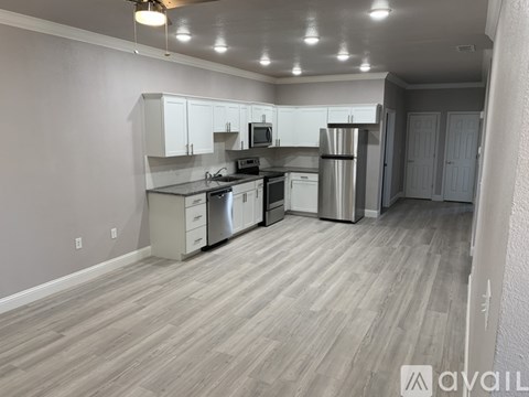 A kitchen with white cabinets and a wooden floor.