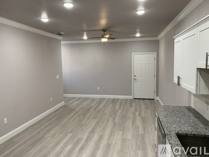 A room with a ceiling fan and a door.