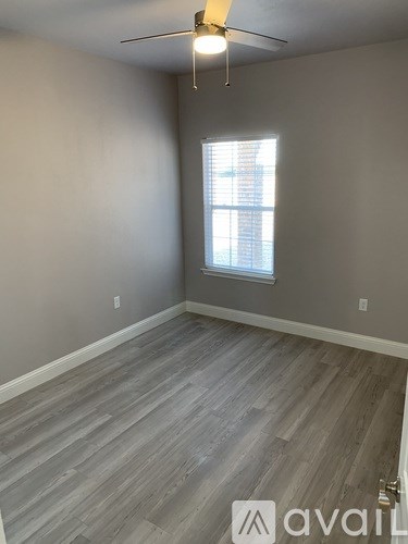 A room with a ceiling fan and a window.