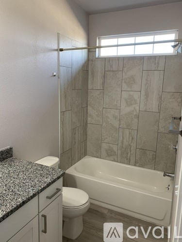 A bathroom with a tub, toilet and sink.