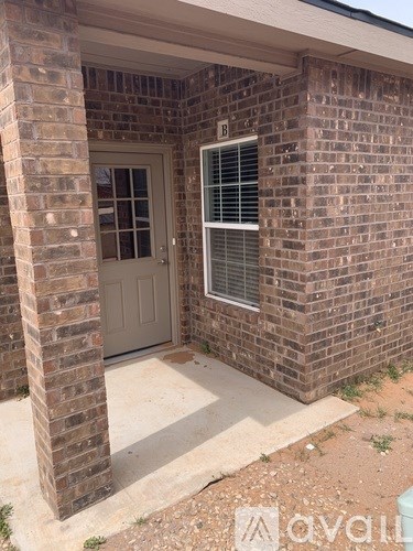 A brick house with a white door and window.