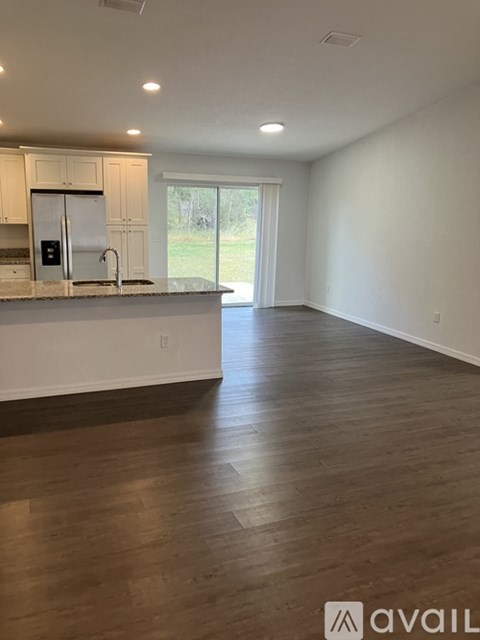 A kitchen with white cabinets and a white fridge with a sink underneath it.