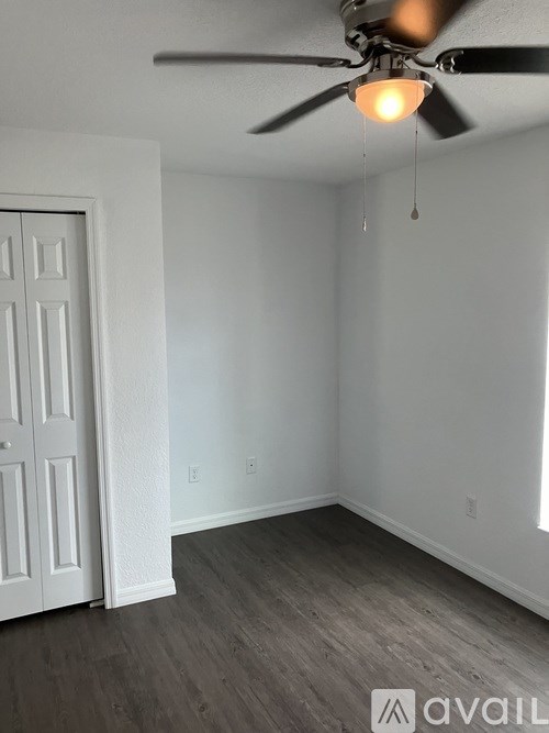 A room with a ceiling fan and a door.