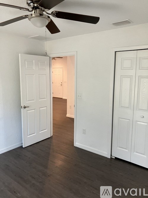 A room with a ceiling fan and two doors.