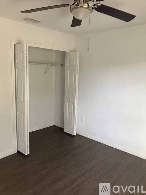 A room with a ceiling fan and a doorway.