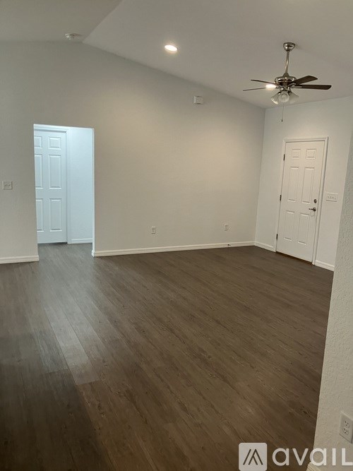 A room with wooden flooring and a ceiling fan.