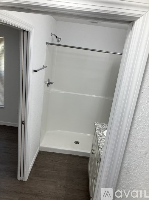 A white bathroom with a walk-in shower and a toilet.
