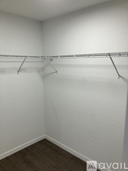 Empty white closet with clothes hangers.