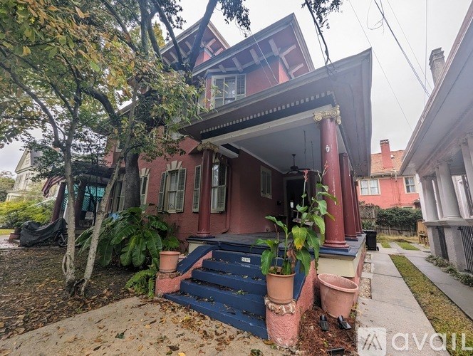 A red house with a blue staircase in front.