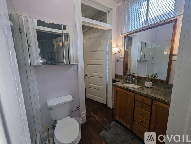 A bathroom with a toilet, sink, and mirror.