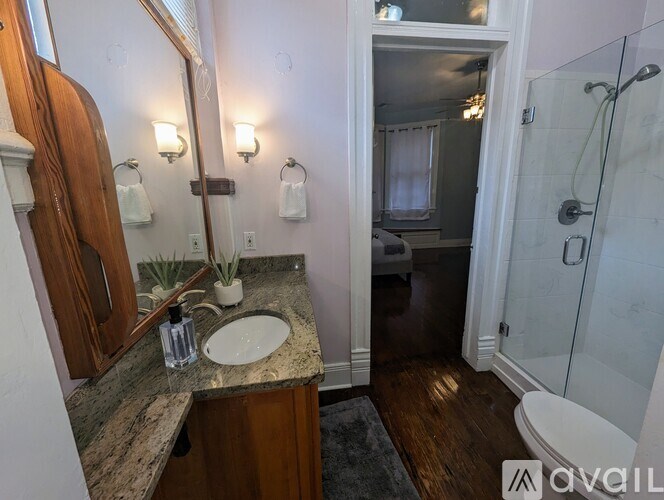 A bathroom with a sink, mirror, and shower.