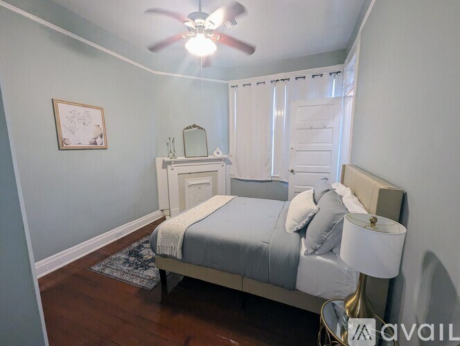 A bedroom with a bed, nightstand, and a ceiling fan.