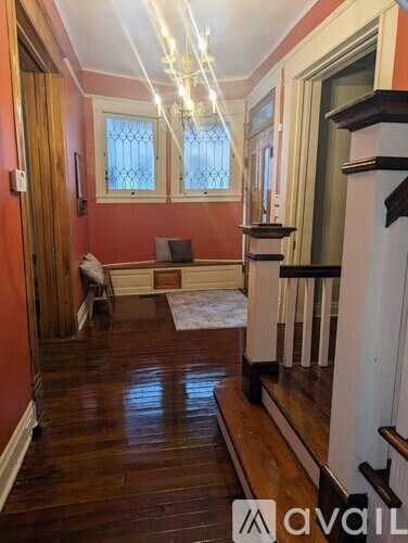 A hallway with wooden floors and a chandelier.