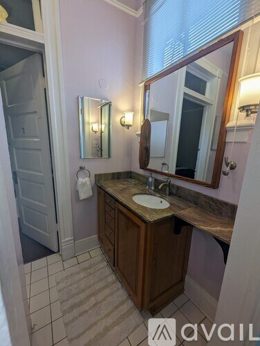 A bathroom with a sink, mirror, and light fixtures.