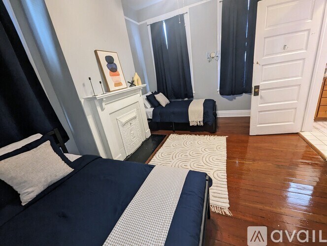 A bedroom with a bed, a couch, and a fireplace.