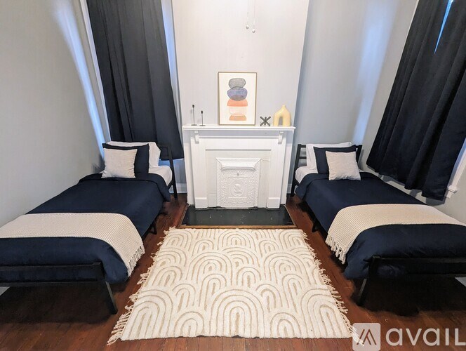 A room with two beds and a fireplace.