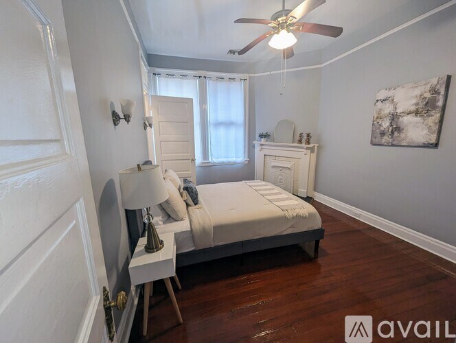 A bedroom with a bed, nightstand, and a painting on the wall.