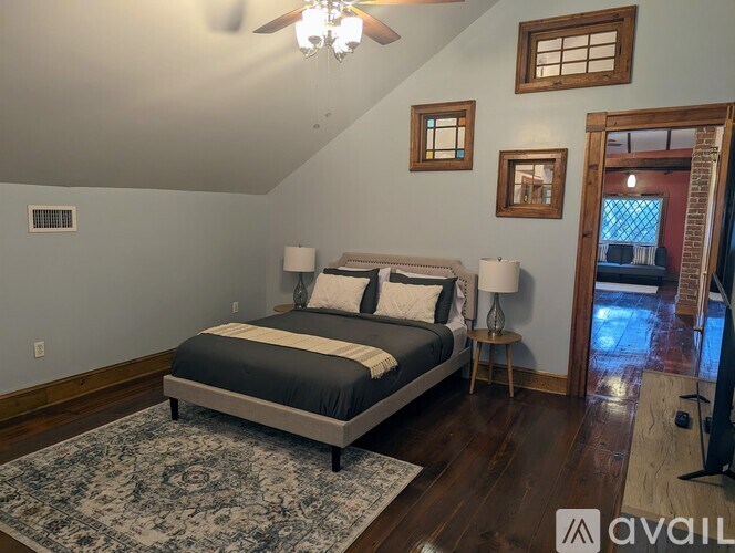 A bedroom with a bed, two lamps, and a ceiling fan.