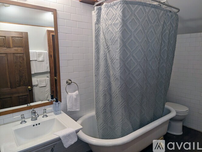 A bathroom with a white sink, a bathtub, and a shower curtain.