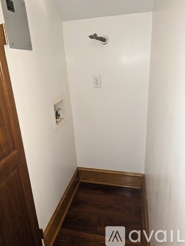 A white wall with a light switch and a small white box on it.