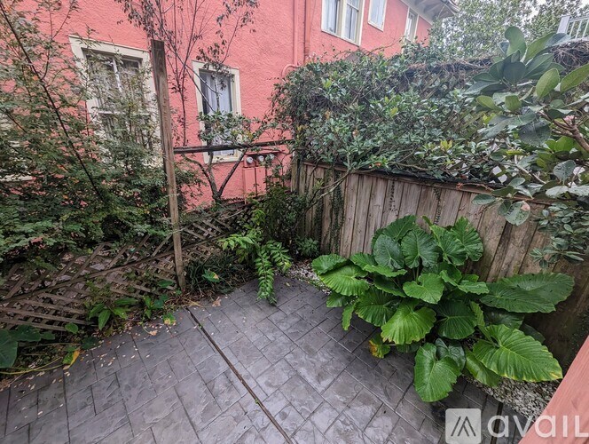 A small backyard with a wooden fence and a brick patio.