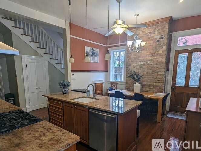 A kitchen with a brick wall and a ceiling fan.