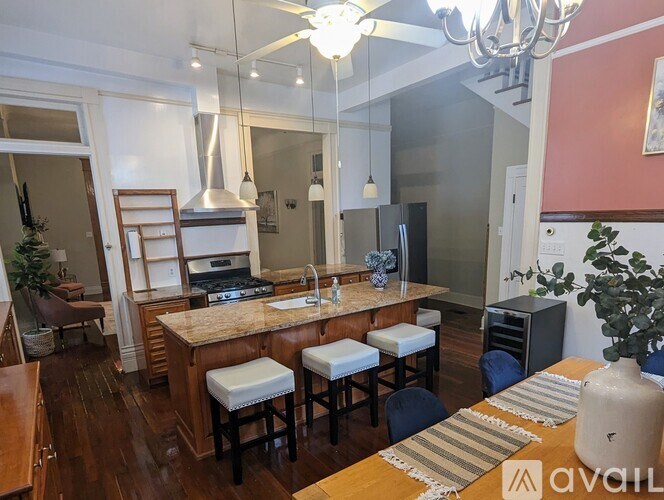 A kitchen with a wooden island and bar stools.