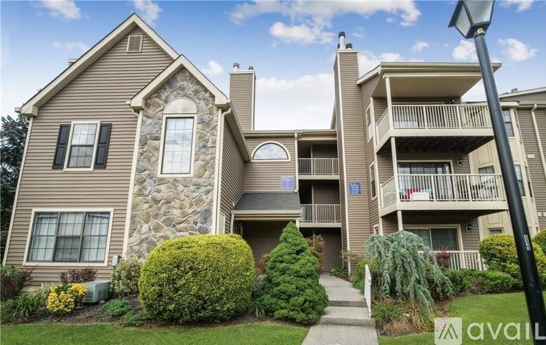 A large house with a stone wall and a balcony.