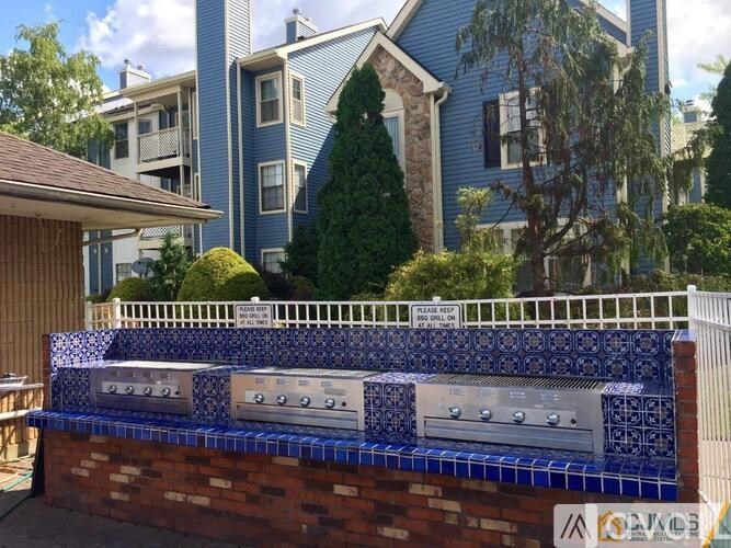 A blue tiled wall with a grill on top.