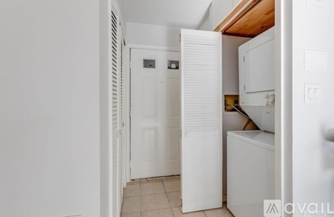 A white refrigerator is in a kitchen with a white door.