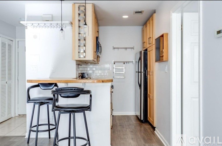 A kitchen with a bar area and a refrigerator.