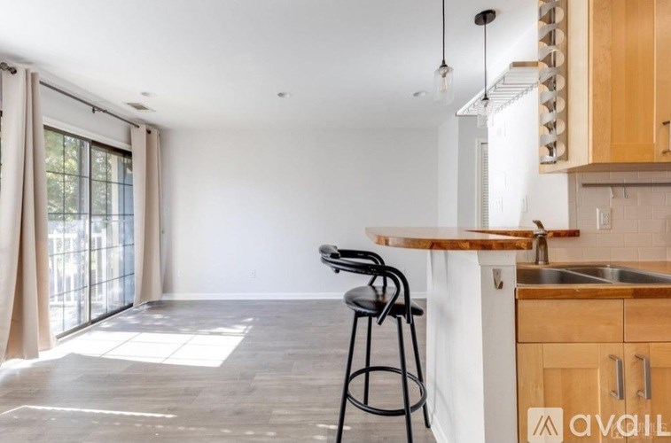 A kitchen with a bar stool in front of a counter.