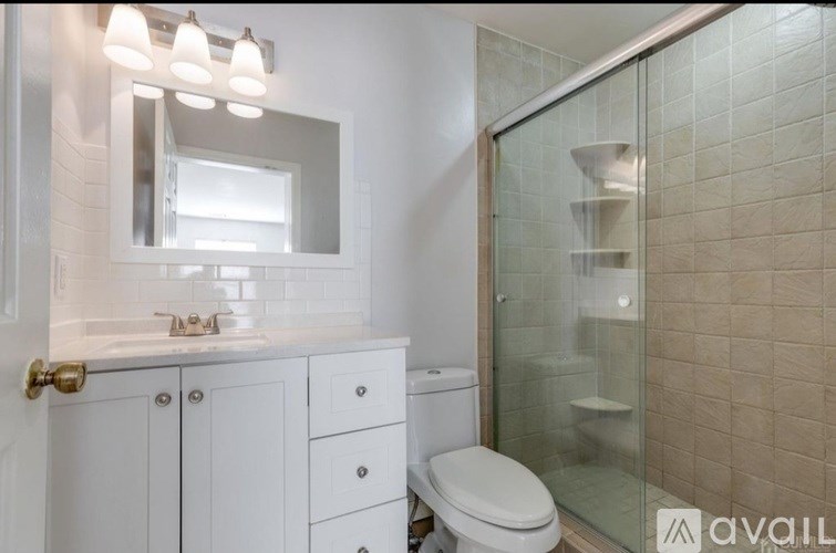 A bathroom with a toilet, sink, and mirror.