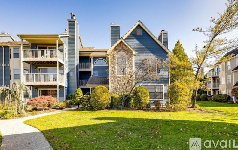 A large house with a balcony and a tree in front.