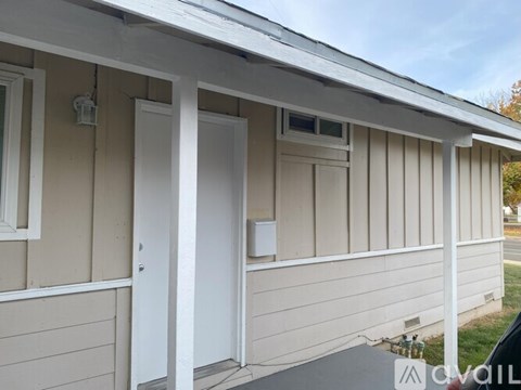A small building with a white door and windows.