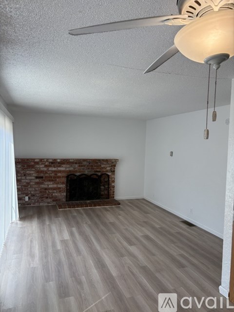 A room with a fireplace and a ceiling fan.