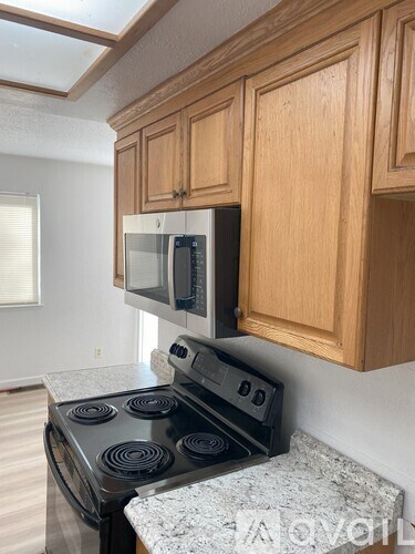 A kitchen with a stove and microwave built into the cabinetry.