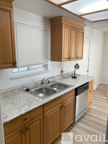 A kitchen with wooden cabinets and a granite countertop.