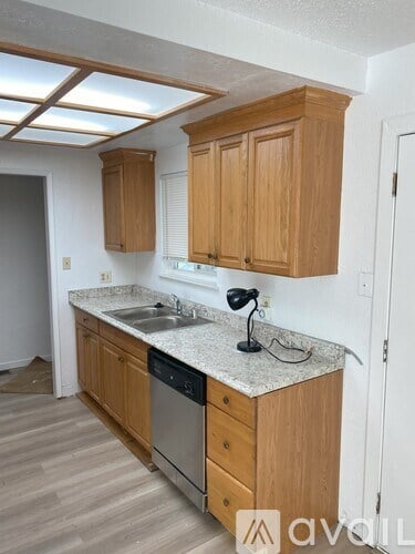 A kitchen with wooden cabinets and a granite countertop.