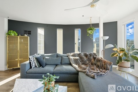 A living room with a grey sofa and a glass cabinet.