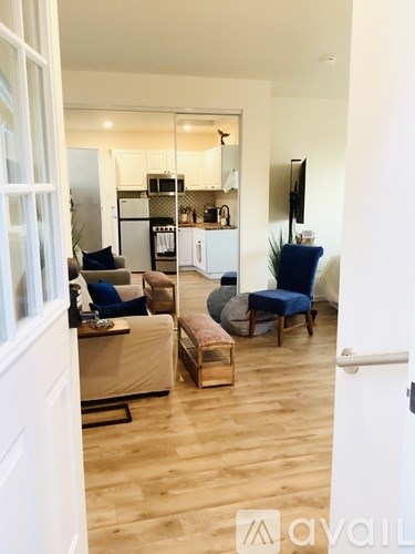 A living room with a couch, chair, and a television.