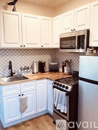 A kitchen with white cabinets and a black stove top oven.