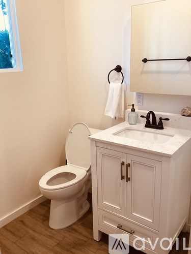 A white toilet and sink in a bathroom.