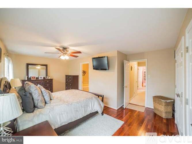 A bedroom with a bed, dresser, and tv.