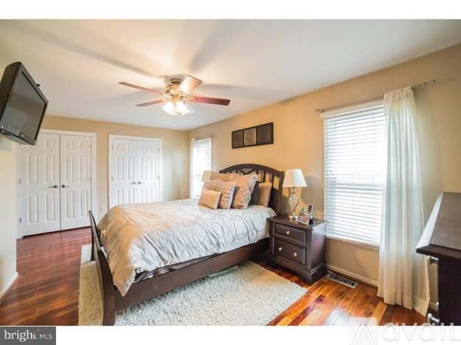 A bedroom with a bed, nightstand, and a ceiling fan.
