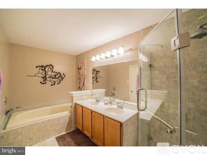 A bathroom with a tub, sink, mirror, and shower.