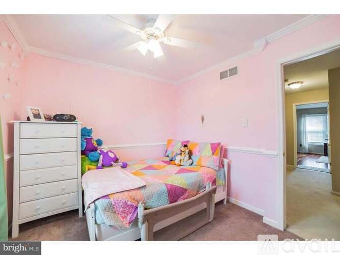 A bedroom with a bed, dresser, and toys.