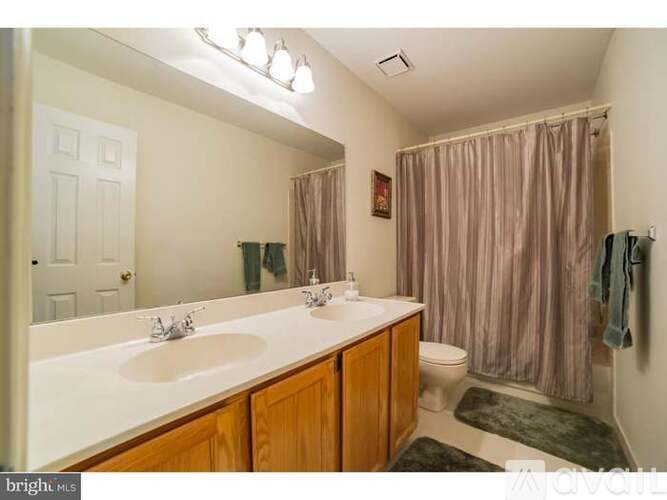 A bathroom with a white countertop and a toilet in the corner.