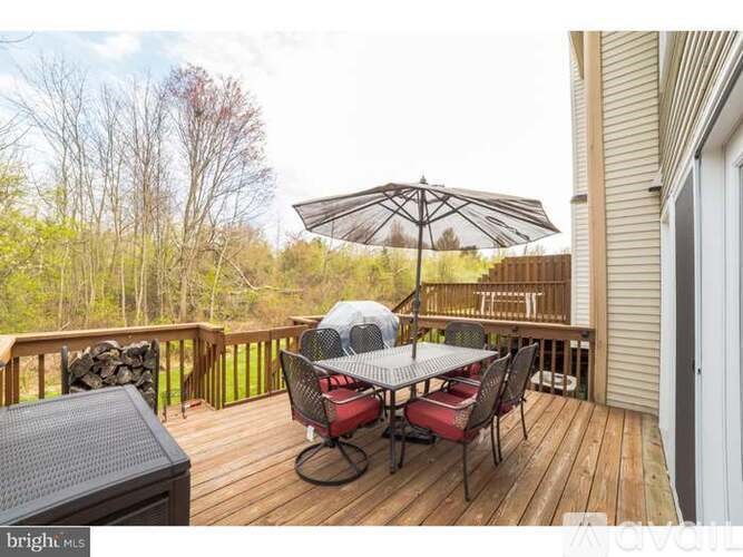 A deck with a table and chairs and an umbrella.
